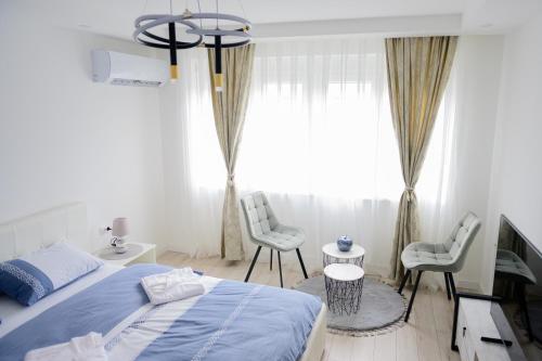 a bedroom with a blue bed and two chairs at Aurora Apartment in Berane