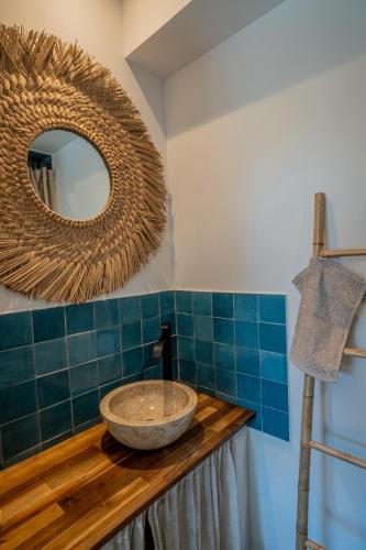une salle de bain avec un lavabo et un miroir dans l'établissement Les chênes verts, à Piolenc