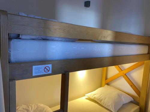 un lit superposé avec un panneau sur la couchette inférieure dans l'établissement Appart rénové cœur station, skis aux pieds, parking, animaux admis - FR-1-513-98, à Courchevel