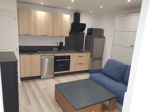 a kitchen with a blue couch and a blue chair at Studio tout équipé in Vaugneray