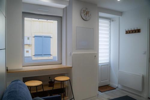 a living room with a window and two stools at Studio tout équipé in Vaugneray