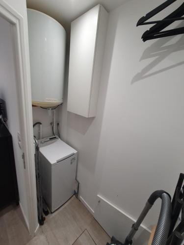 a laundry room with a refrigerator and a cabinet at Studio tout équipé in Vaugneray