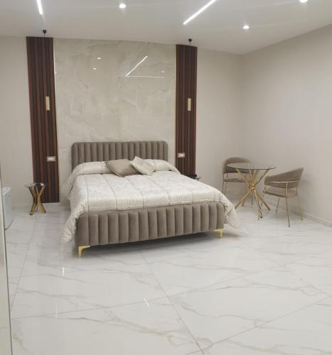 a bedroom with a bed and a table and chairs at REDAMARE SUITE in Lago Patria