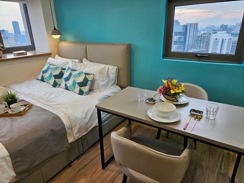 a small room with a bed and a table with chairs at SerenityStayatRiveria KL Sentral in Kuala Lumpur