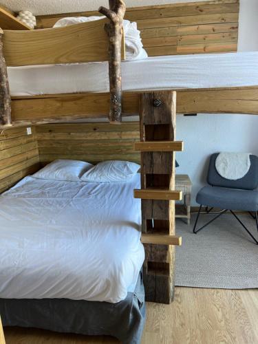 - une chambre avec des lits superposés et une chaise bleue dans l'établissement Appartement cosy Le Corbier Lunik Orion, à Villarembert