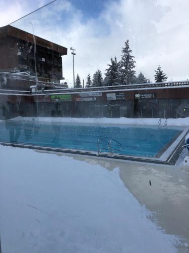 une piscine avec de la neige devant un bâtiment dans l'établissement Appartement cosy Le Corbier Lunik Orion, à Villarembert
