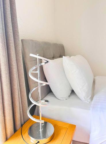 a bed with white pillows and a towel rack on it at Anchor's Drop in Blue Anchor