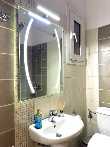 a bathroom with a sink and a mirror and a toilet at Larissa city ap 7 with parking in Larisa