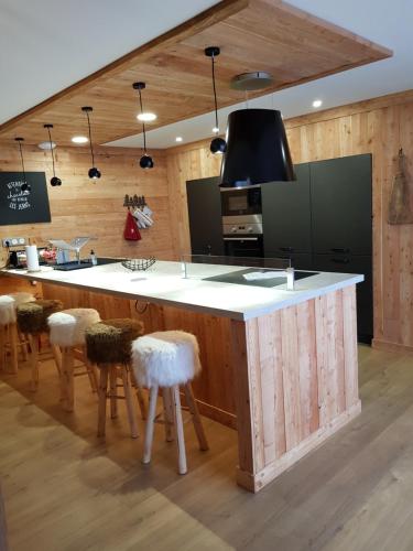 une cuisine avec un grand îlot et des tabourets dans l'établissement Le Montcalm chalet Le Desman, à Ustou