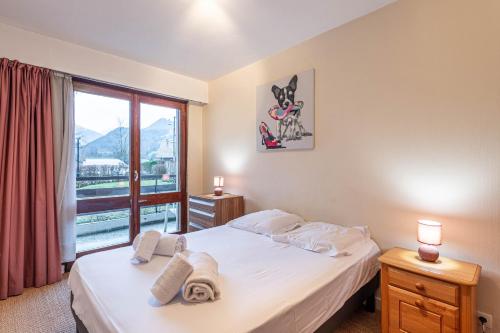 une chambre avec un lit et une grande fenêtre dans l'établissement Smartstay massif mont blanc - Saint gervais, à Saint-Gervais-les-Bains