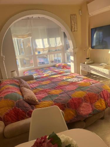 a bedroom with a bed with a colorful blanket at Estudio Zurycris in Torrox Costa