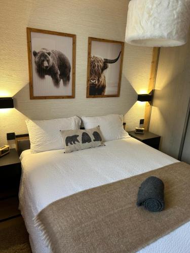 - une chambre dotée d'un grand lit blanc avec des photos sur le mur dans l'établissement NOUVEAU appartement neuf 4 à 6 personnes dans la station du Chinaillon, Grand-Bornand, au Chinaillon