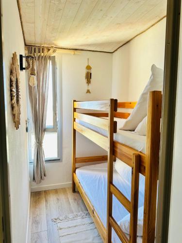 une chambre avec deux lits superposés et une fenêtre dans l'établissement Appartement 1 pièce vue mer, à Leucate
