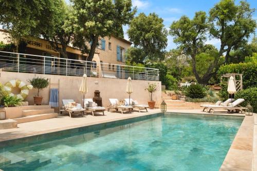 - une piscine avec des chaises longues et des chaises à côté d'un bâtiment dans l'établissement Villa Quercia Grand Confort dans Oasis de Calme, à Fréjus