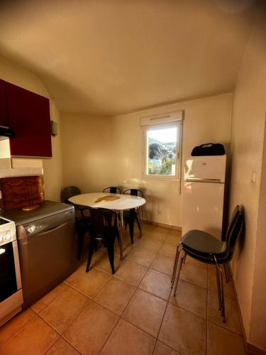 une cuisine avec une table, des chaises et un réfrigérateur dans l'établissement Résidence KALLISTE, à Monticello