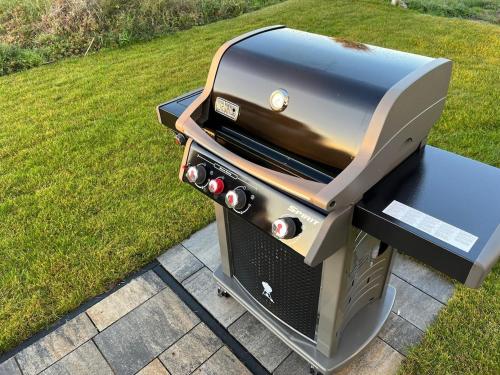 a bbq grill sitting on a patio at HausLIEBLINGSPLATZ - am Meer - Luxus Villa mit 4 Schlafzimmern, 3 Badezimmern Sauna, Kamin, Weber-Grill und Wallbox in Dranske
