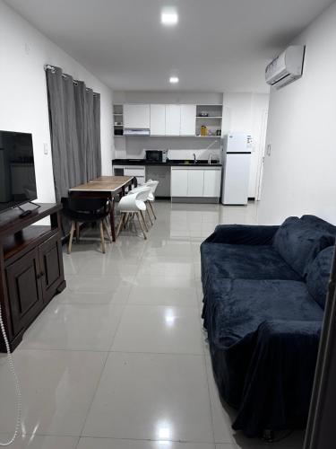 a living room and kitchen with a couch and a table at Edificio Victoria in Encarnación