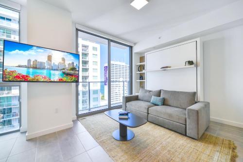 a living room with a couch and a flat screen tv at Great Miami Stay Steps from Bayside & the Beach in Miami