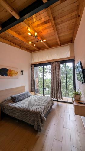 a bedroom with a bed and a large window at Cabaña La Finca Mazamitla in Mazamitla