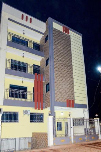 un gran edificio blanco con ventanas rojas por la noche en Appartement standing avion, en Yaoundé