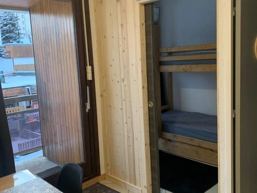 une chambre avec deux lits superposés et une fenêtre dans l'établissement Studio lumineux 5 pers, 50m des pistes avec balcons ensoleillés - FR-1-416-225, à La Toussuire
