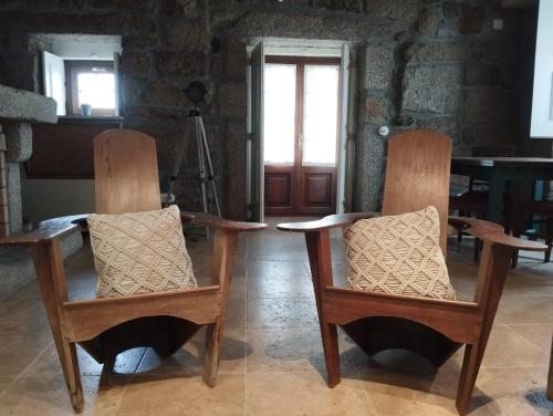 a couple of chairs sitting in a room at Casa dos Livros - Guest House in Vila Nova de Tazem