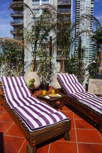 two lounge chairs and a table on a patio at Shoshana Hotel Boutique in Buenos Aires