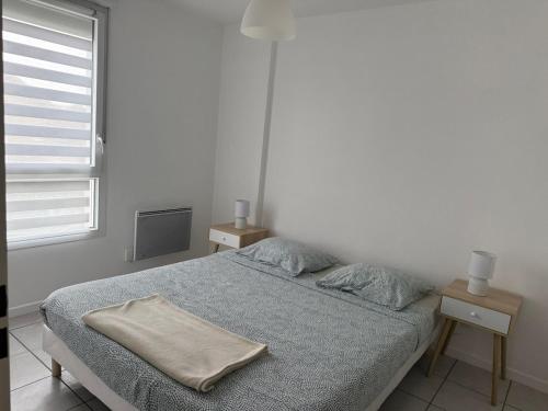 une chambre blanche avec un lit et deux tables de nuit dans l'établissement Chez Noah - 70m2 near Geneva, à Ville-la-Grand
