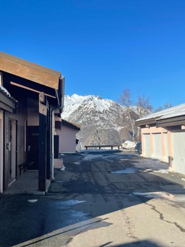 an empty street with a snow covered mountain in the background at Petit appartement Labellisé Les 2 Alpes résidence Arc en Ciel télésiège Petite Aiguille in Les Deux Alpes