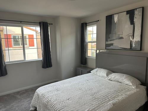 a bedroom with a white bed and two windows at Gated Upland Home 3b 3 bath in Upland