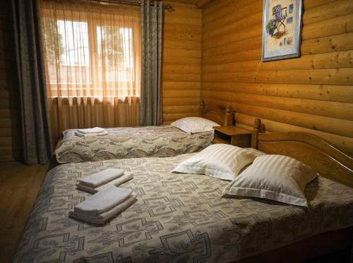 two beds in a log cabin with towels on them at Greku Hotel in Bukovel