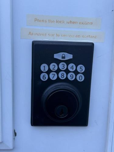 a sign that says press the lock when exiting an appliance at Charmant appartement au sous-sol in Longueuil