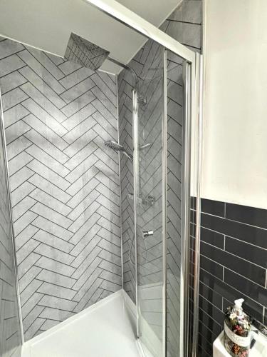 a shower with a glass door in a bathroom at CityZen - serviced accomodation in Birmingham