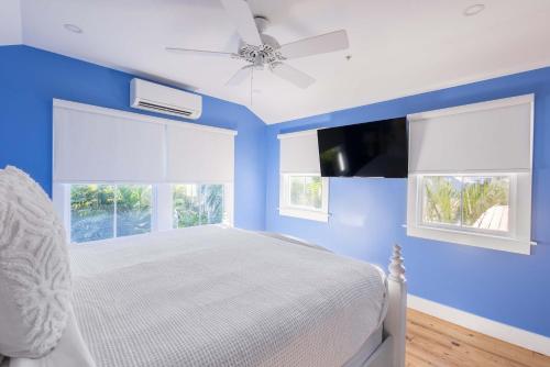 a blue bedroom with a bed and a ceiling fan at Keys Please! in Key West