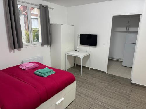 - une chambre avec un lit rouge et une télévision dans l'établissement Appartement H, RESIDENCE DU RENOUVEAU, Stade de France, idéal pour 2 pers, à Saint-Denis