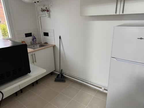 La cuisine est équipée d'un réfrigérateur et d'un évier. dans l'établissement Appartement H, RESIDENCE DU RENOUVEAU, Stade de France, idéal pour 2 pers, à Saint-Denis