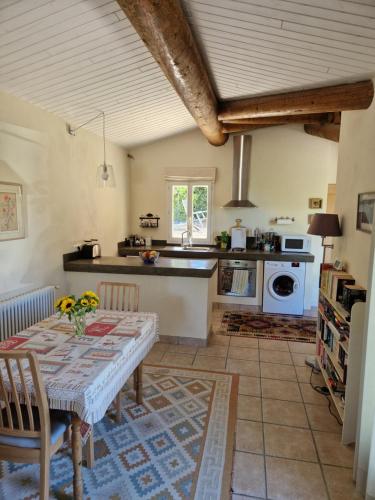 a kitchen with a table with flowers on it at The Neame House in Bédoin