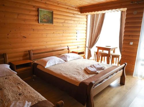 a bedroom with a bed in a log cabin at Greku Hotel in Bukovel