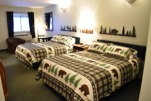 a hotel room with two beds and a chair at 4 Season Fun at Legend Cottage Inn in Bellaire