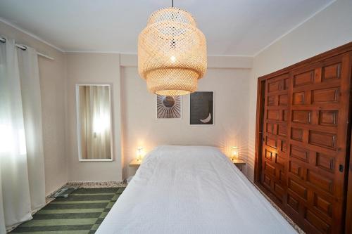 ein Schlafzimmer mit einem großen Bett und einem Kronleuchter in der Unterkunft Cielo Azul in Nerja