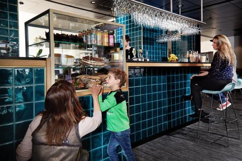 a woman and a young boy eating food at a bar at Danhostel Copenhagen City & Apartments in Copenhagen