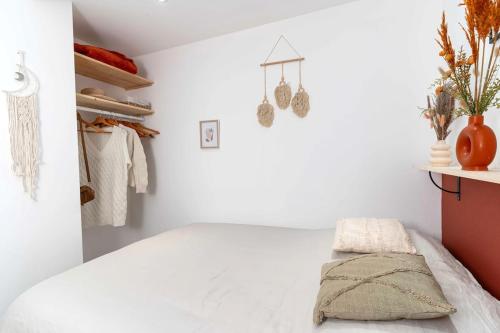 - une chambre blanche avec un lit et une étagère dans l'établissement Appartement atypique et cosy centre-ville, à Strasbourg