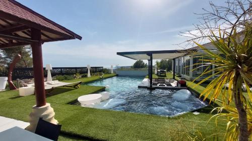 une cour arrière avec une piscine et une maison dans l'établissement Fabuleuse villa Marseille -7 chambres -14 pers avec grande piscine 2 jacuzzis, à Marseille