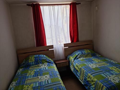 two beds in a small room with a window at Acogedor, cómodo y central. in La Serena