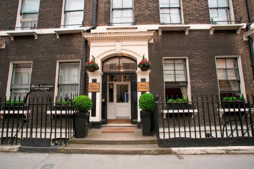 a brick house with a white door and flowers at Hotel Cavendish - Bloomsbury in London