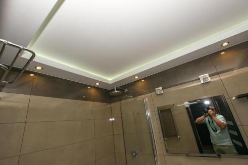 a man taking a picture of a mirror in a bathroom at Apartament Lena in Suwałki