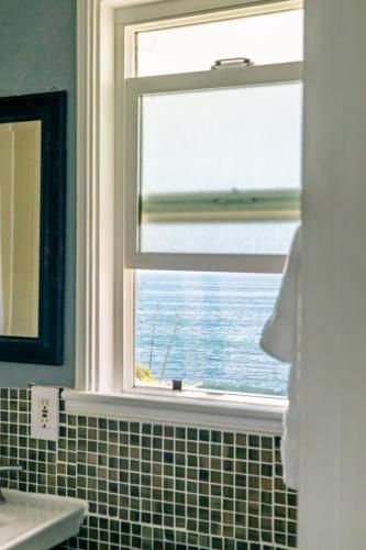 a bathroom with a window with a view of the ocean at Laguna Cove Hotel in Laguna Beach