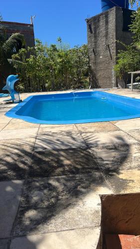 a large blue swimming pool in a yard at Chalé R&M in Aracati