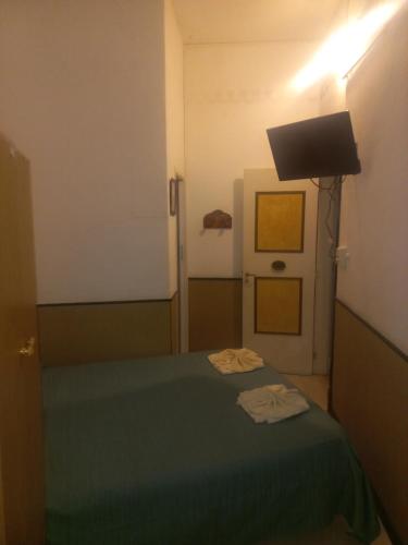 - une chambre avec un lit vert et une télévision dans l'établissement Hosteria mundo tablas, à Mar del Plata