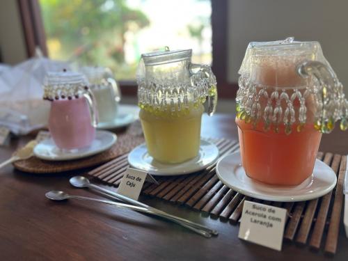 Twee drankjes op borden op een houten tafel. bij Eco Pousada Villa Verde in Bonito